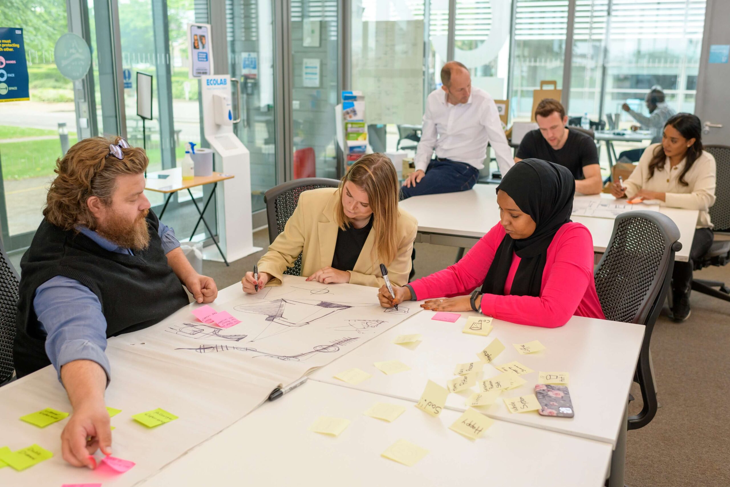 Three people brainstorming ideas using sticky notes