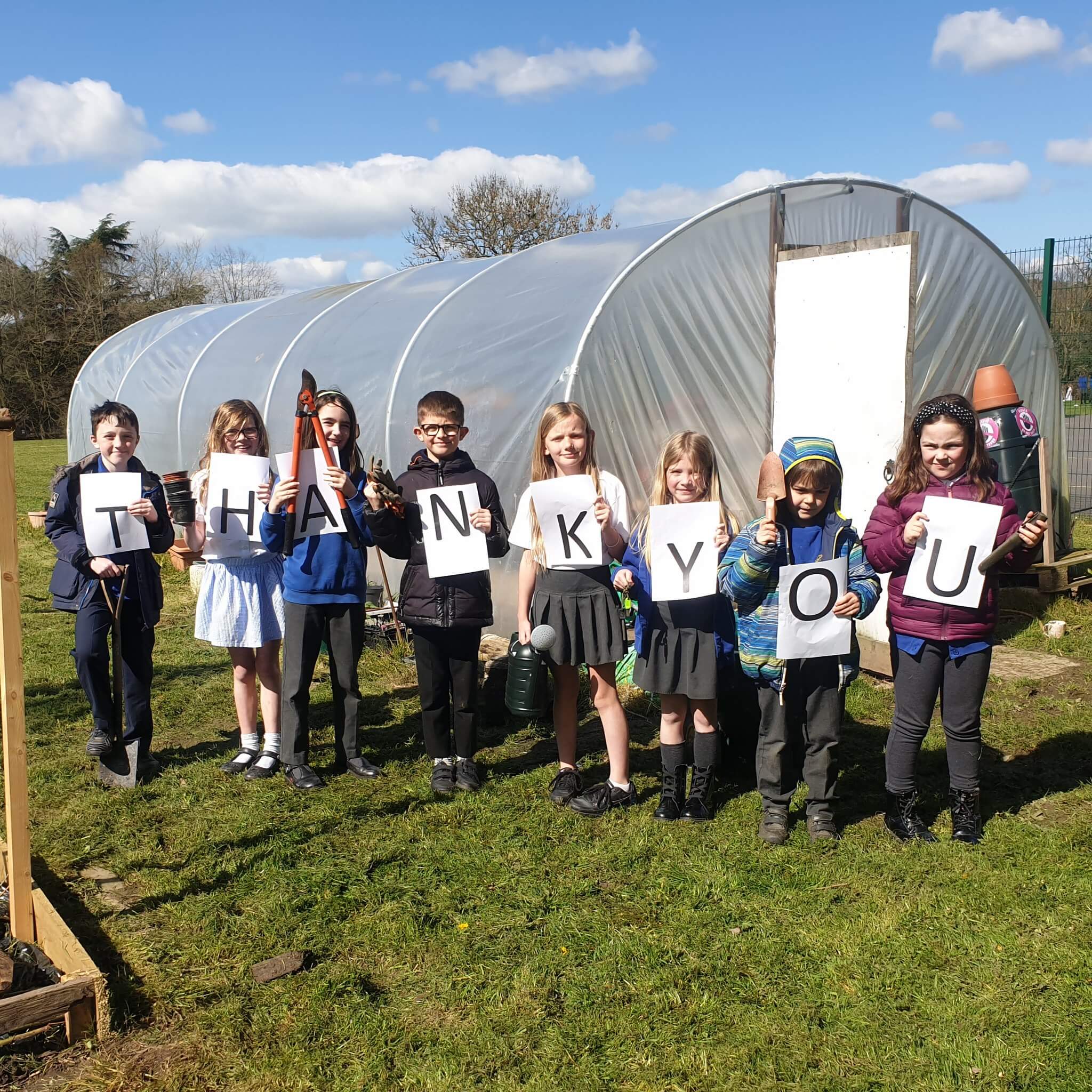 Children holding a sign saying 'THANK YOU'